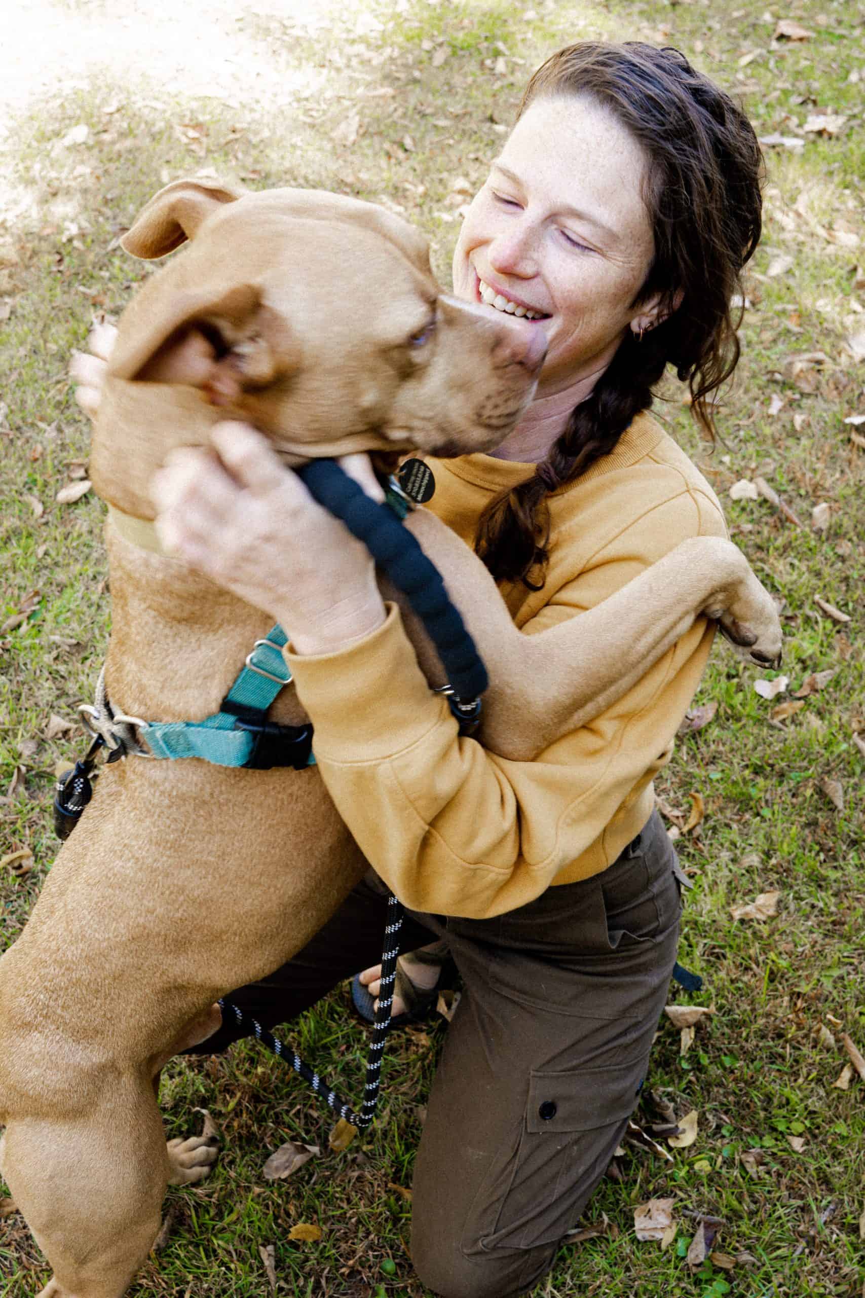 woman with pitbull hugging
