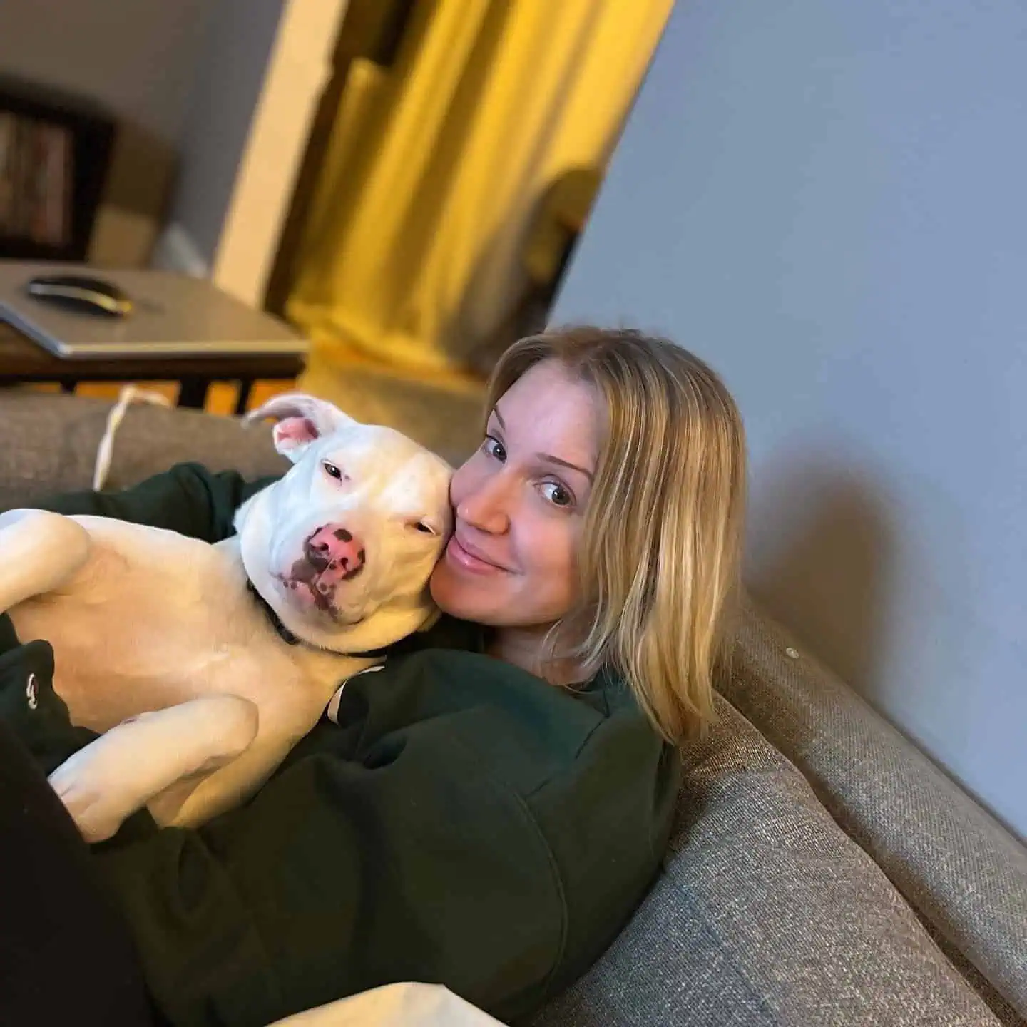 woman sitting on couch with white dog