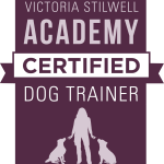 The image is a purple rectangle with a matching ribbon going across the top. There is a silhouette of a person standing and pointing to two dogs sitting on either side of them. White text above reads 