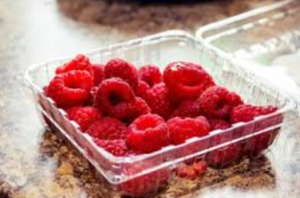 stock photo of a plastic clamshell box filled with raspberries to be used for dog enrichment